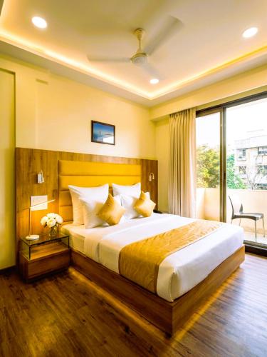 a bedroom with a large bed and a large window at Hotel National - Grant Road in Mumbai
