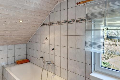 a bathroom with a bath tub and a window at Fewo Tanja's Blumenparadies in Hollfeld