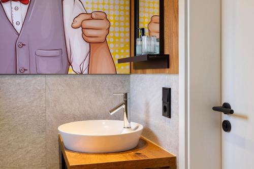 a bathroom with a sink and a poster of a man at Ferienhaus Buwesch 13 in Nüsttal