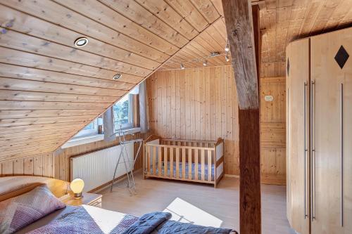 a room with a wooden ceiling with a crib in it at Fewo Tanja's Blumenparadies in Hollfeld