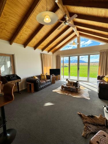 a living room with couches and a ceiling fan at Omahau Down in Lake Pukaki