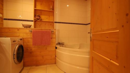 a bathroom with a tub and a washing machine at Chalet Alpaga 6 in Bonneval-sur-Arc