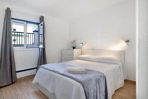 a white bedroom with a bed and a window at Casa Gloria in Puerto del Carmen