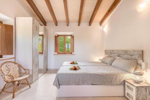 a bedroom with a large bed and a chair at Finca Son Palanca in Sineu