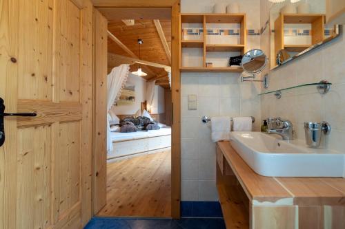 a bathroom with a sink and a bedroom at Rossalm in Brixen