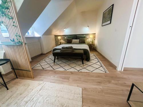 a bedroom with a large bed in a attic at Les Trois Mouettes - Grand appartement familial in Saint-Brieuc