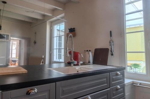 a kitchen with a sink and a black counter top at Les Hirondelles Archiac in Archiac