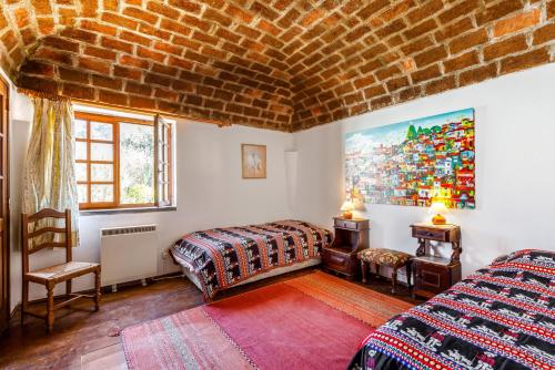a bedroom with two beds and a painting on the wall at Casa do Mar in Sesimbra