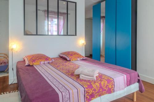 a bedroom with a large bed with a purple blanket at Les Hirondelles Archiac in Archiac