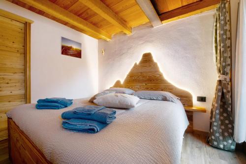 a bedroom with a bed with blue towels on it at Maison Olga in Valtournenche