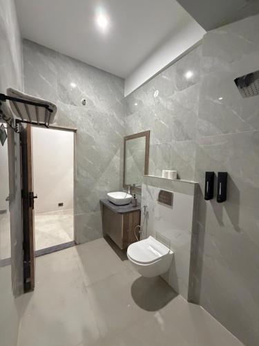 a bathroom with a toilet and a sink at Kaashi Flora Whitehouse-9BHK in Varanasi