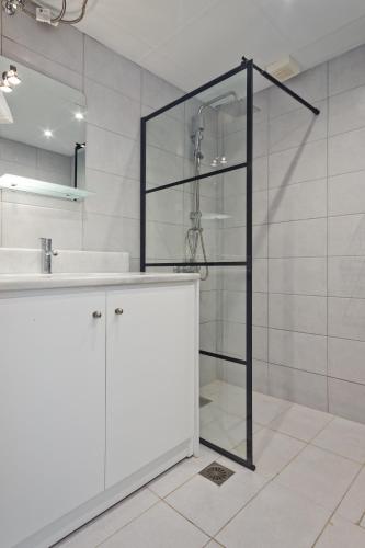 a glass shower in a bathroom with a sink at Helios Apartment 2 in Karpathos
