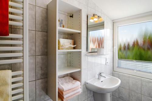 a small bathroom with a sink and a window at Huus Nördernee 2 in Norderney