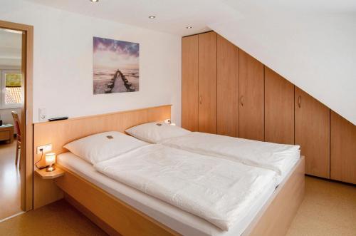 a bed with a wooden headboard in a room at Huus Nördernee 2 in Norderney