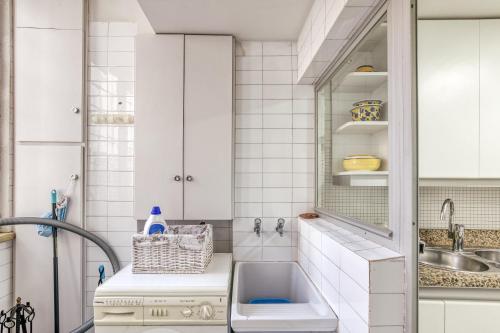 a kitchen with white cabinets and a sink at Carrer del Mar in Palamós