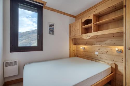 a small bedroom with a bed and a window at Appartement N° 46 in Les Menuires
