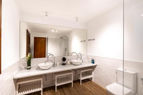 a bathroom with two sinks and a large mirror at The Cube in Zahara de los Atunes