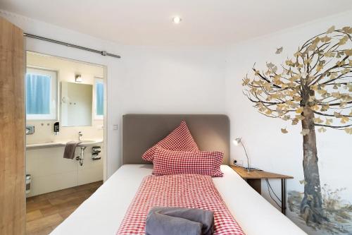 a bedroom with a bed and a tree in it at Holzwurm Apartments in Sasbachwalden
