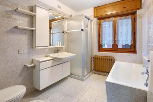 a bathroom with a sink and a toilet and a tub at Lovin Summer in Livigno