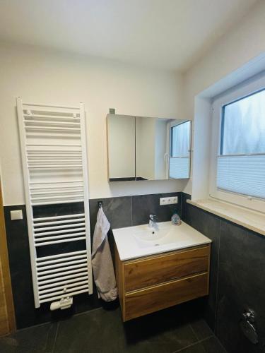 a bathroom with a sink and a window at Ferienwohnung Adelsried 1 in Adelsried