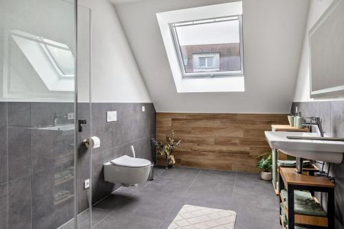 a bathroom with a toilet and a sink and a skylight at Fewo Ebringen Vogesenblick in Ebringen