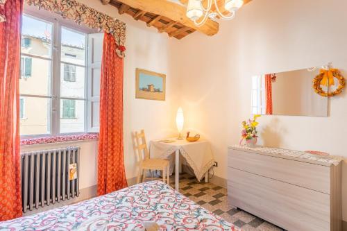 ein Schlafzimmer mit einem Tisch, einem Bett und einem Fenster in der Unterkunft Mangiafuoco in Collodi