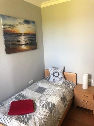 a bedroom with a bed and a painting on the wall at Wellness Penthouse Meerblick in Sierksdorf