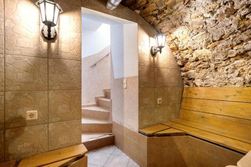 a bathroom with a stone wall with a bench and stairs at Ferienanlage in Großkoschen