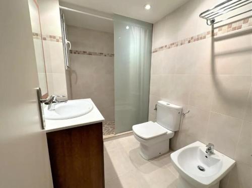 a bathroom with a toilet and a sink and a mirror at Eden Mar Calonge Girona in Calonge