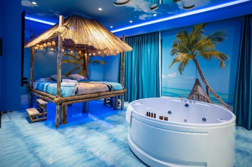 a room with a bed and a tub at Hotel Art Village in Casoria