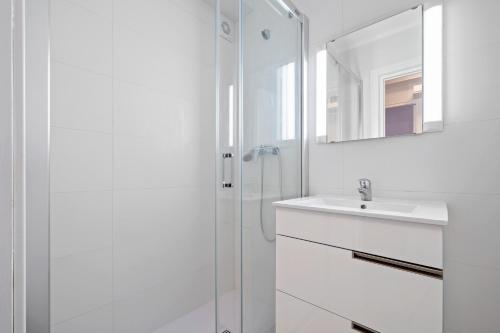 a white bathroom with a sink and a shower at Formentor 863 in Salou