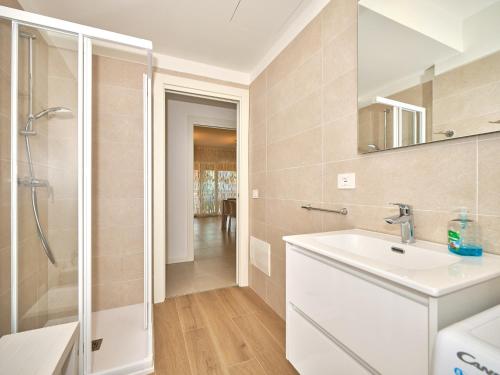 a white bathroom with a sink and a shower at New Casa Augusto in Lazise