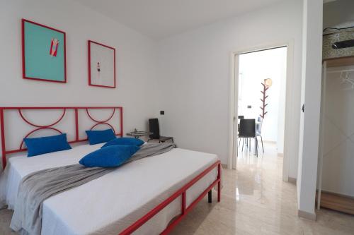 a bedroom with a large bed with blue pillows at Casa Malika a Otranto in Otranto
