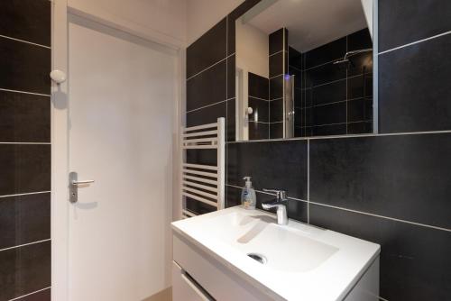 a bathroom with a white sink and a mirror at Domaine de l'Arbizon in Bagnères-de-Bigorre