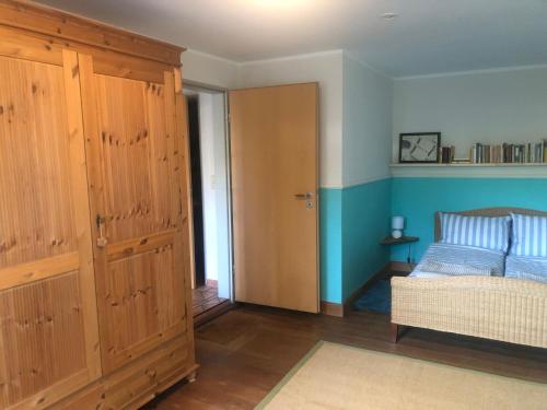 ein Schlafzimmer mit einem Bett und einem großen Holzschrank in der Unterkunft Bücherträume in Windeby