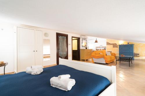 a bedroom with two towels on a blue bed at Giojas125 Monolocale per 4 persone in Orosei