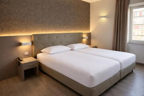 a bedroom with a large white bed and a window at LVG Hotel Collection - Principe in Modena