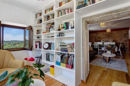 a room with a large book shelf filled with books at Casa Do Pião - Turismo Rural in Ancião
