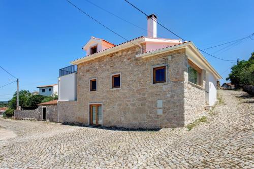 a stone house on a cobblestone street at Casa Do Pião - Turismo Rural in Ancião