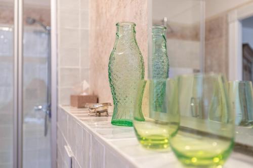 a row of green glass vases sitting on a counter at Wohnoase im Denkmal in Garding