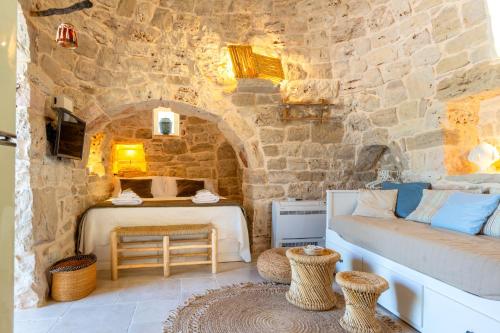 a bedroom with a bed and a stone wall at Il Trullo di Mariangela in Ceglie Messapica