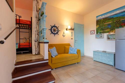 a living room with a yellow chair and a bunk bed at Casa Erica in Stintino