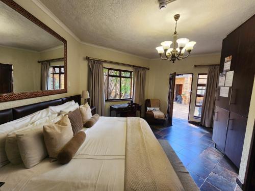 a bedroom with a large white bed with a large mirror at Goodnight Guest Lodge in Johannesburg
