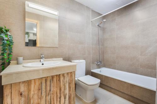a bathroom with a sink and a toilet and a bath tub at Oceanfront Apartment With Pool in El Cotillo