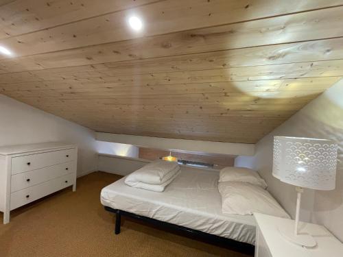 a bedroom with a bed and a wooden ceiling at La Tomate Surfeuse 1 in Hourtin