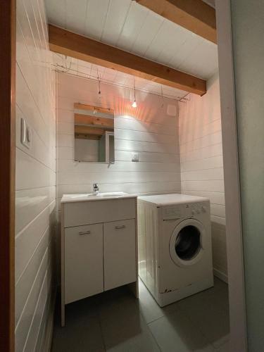 a laundry room with a sink and a washing machine at La Tomate Surfeuse 1 in Hourtin