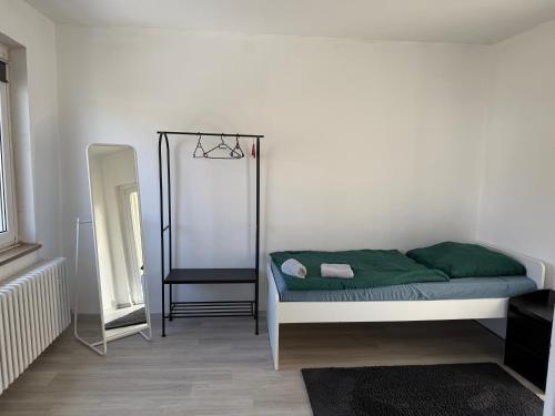 a bedroom with a bed with a green blanket and a mirror at Schöne 3 Zimmer Wohnung in Bad Salzuflen in Bad Salzuflen