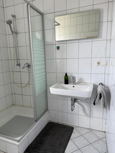 a white bathroom with a sink and a shower at Schöne 3 Zimmer Wohnung in Bad Salzuflen in Bad Salzuflen