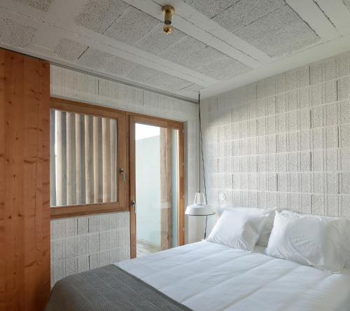 a bedroom with a white bed and a window at Fisherman's Blues - Beach House in Arcozelo
