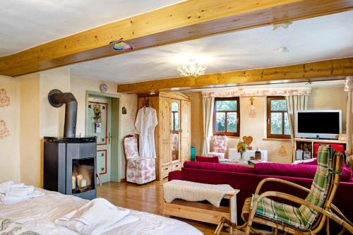 a living room with a red couch and a fireplace at Ferienwohnung-Cottage Rhöner Kräute in Buttlar